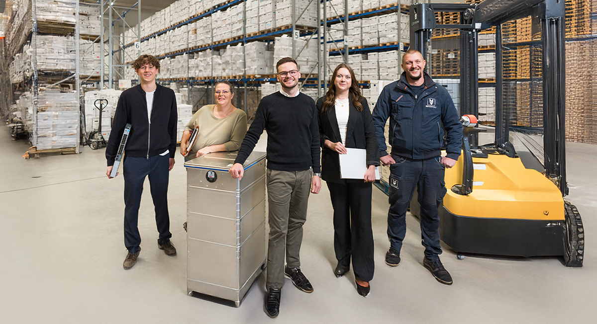 REISSWOLF B2B-Team mit Logistik-Experten und Sicherheitsbehälter im Archivlager für Datensicherheit und professionelle Aktenvernichtung.