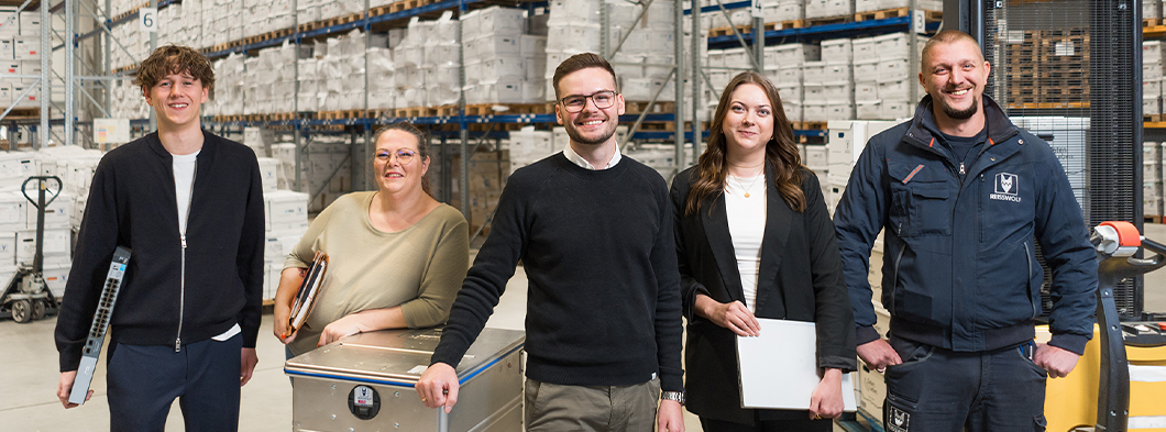 REISSWOLF B2B-Team mit Logistik-Experten und Sicherheitsbehälter im Archivlager für Datensicherheit und professionelle Aktenvernichtung.