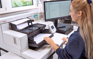 Mitarbeiterin scannt Papierdokumente mit professionellem Kodak-Dokumentenscanner