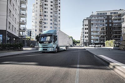 Volvo FL electric truck crossing a city avenue.