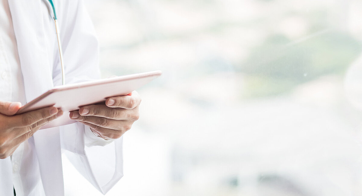 Ein Arzt hält ein Tablet-Computer.