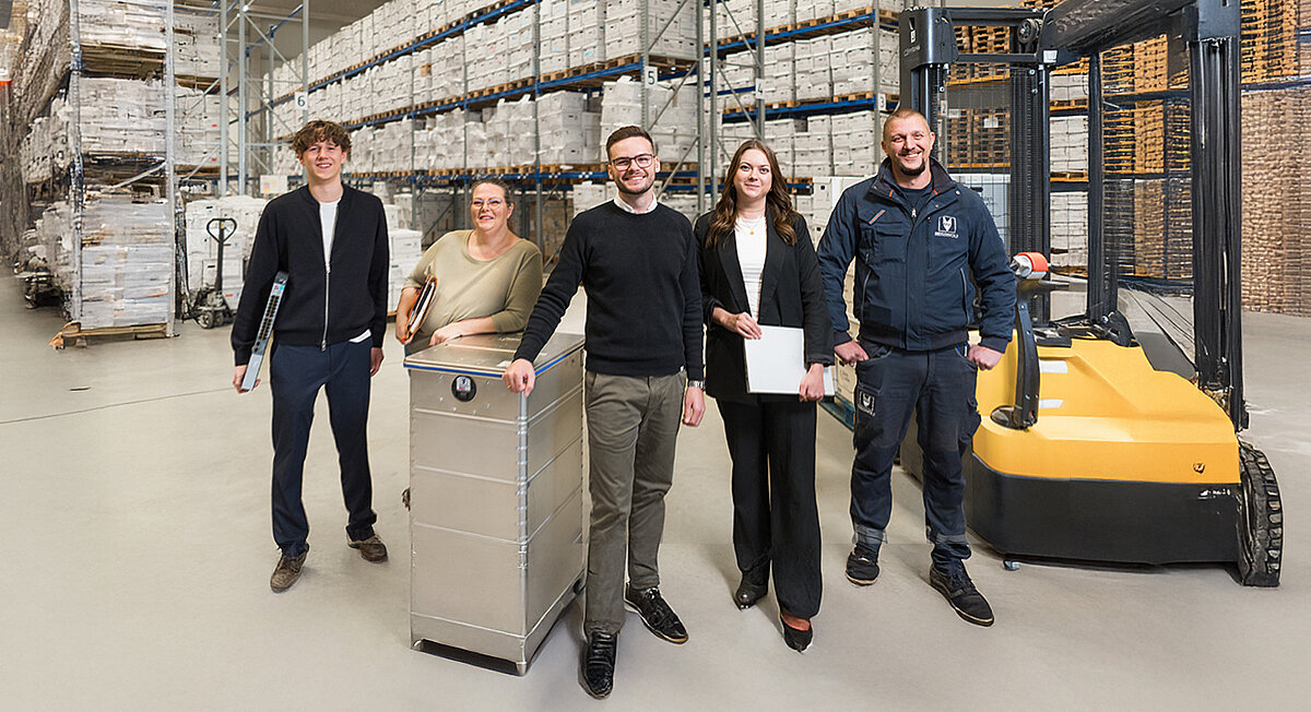 REISSWOLF B2B-Team mit Logistik-Experten und Sicherheitsbehälter im Archivlager für Datensicherheit und professionelle Aktenvernichtung.