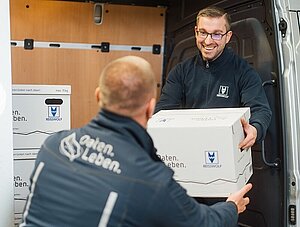 REISSWOLF Mitarbeiter übergibt Archivkarton an weiteren Mitarbeiter