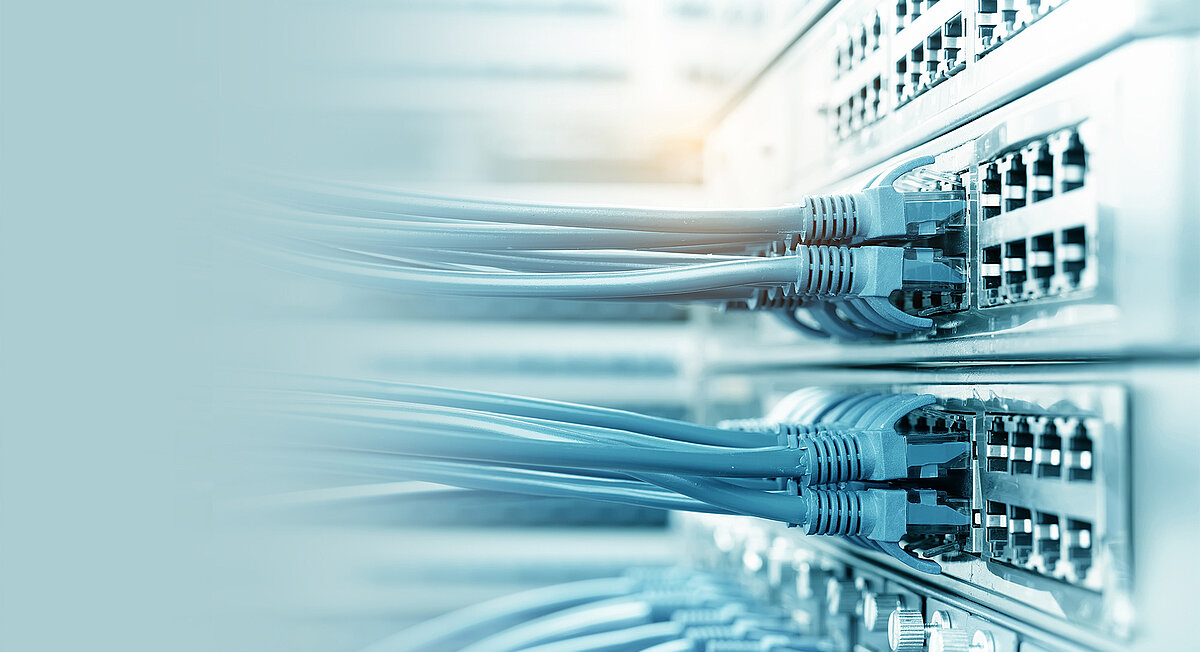 Nahaufnahme eines Netzwerkservers mit blauen Kabeln.