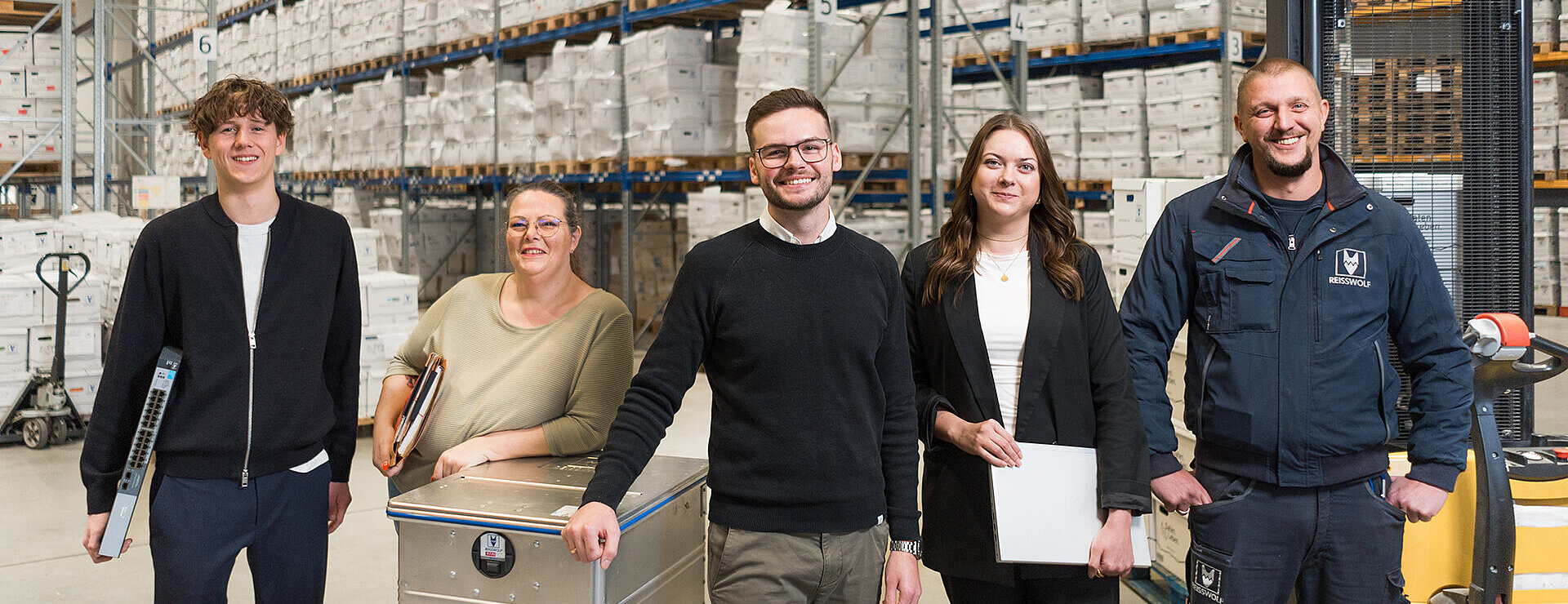 Mitarbeiterinnen und Mitarbeiter von REISSWOLF im Archivlager mit Dokumentenboxen