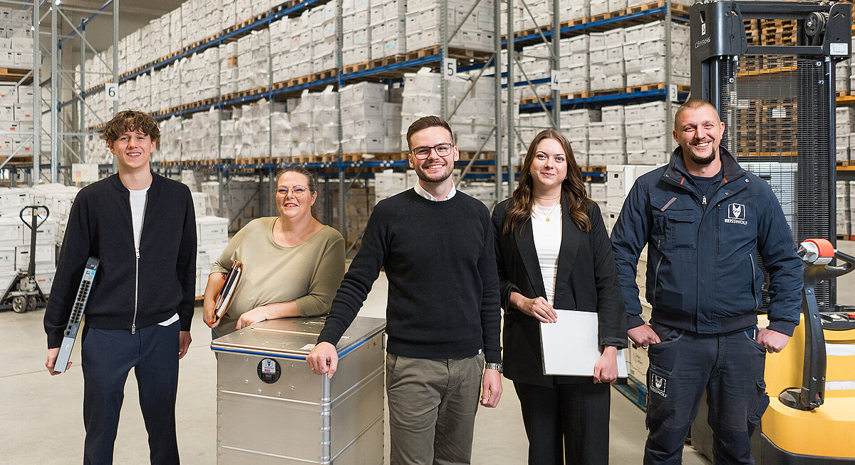 Mitarbeiterinnen und Mitarbeiter von REISSWOLF im Archivlager mit Dokumentenboxen