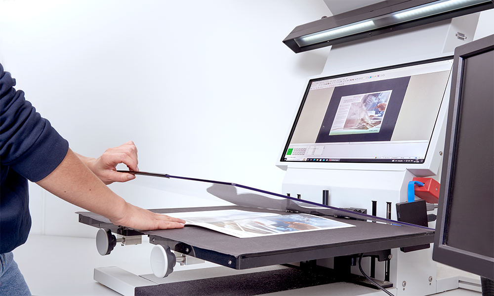 Mitarbeiter bedient Aufsichtsscanner zur Digitalisierung von gebundenen Dokumenten